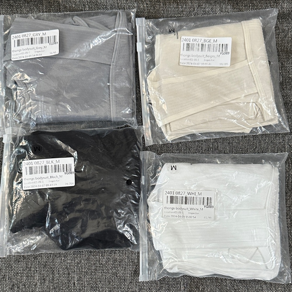 Women’s 4 pack medium size thong body suit. Black , grey , beige and white